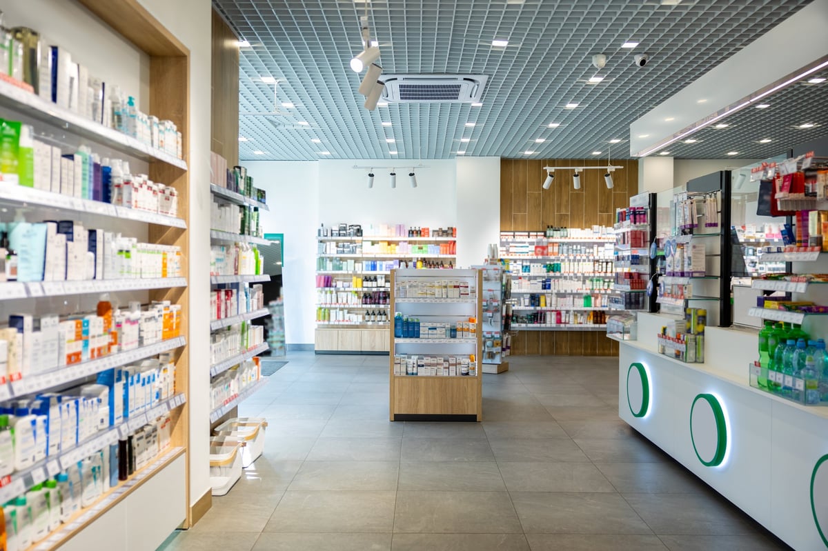 Modern pharmacy store interior with various shelves displaying medicines and healthcare products
